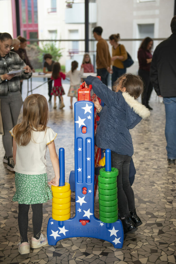 Enfants qui jouent sur un puissance 4 géant. 80 ans de l'udaf 24